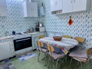 a kitchen with a table and chairs and a table and a stove at Dar El Mdina in Mahdia