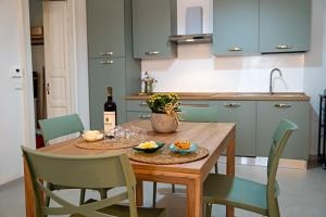 a kitchen with a wooden table with a bottle of wine at Dimora Noè e Concettina in Botrugno