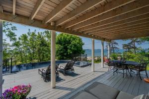 a wooden deck with a table and chairs on it at Waterfront Cottage w Pool Beach Access in Fort Erie