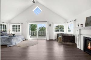 a white room with a bed and a fireplace at Waterfront Cottage w Pool Beach Access in Fort Erie +43 photos