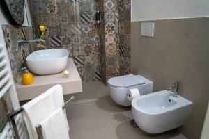 a bathroom with a white toilet and a sink at Dimora Noè e Concettina in Botrugno