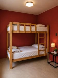 two bunk beds in a room with a red wall at Paracas Desert Lodge&Tours in Paracas +73 photos