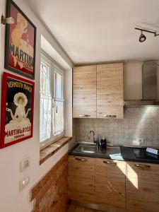 a kitchen with wooden cabinets and a poster on the wall at Corte Magnolia Terme & Lago di Garda in Colà di Lazise