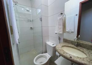 a bathroom with a shower and a toilet and a sink at Dali Apart hotel in Ipatinga