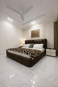 a bedroom with a large bed and a ceiling at Second Stay apartments in Faisalabad
