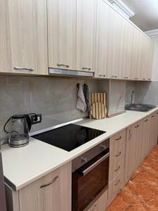 a kitchen with white counters and wooden cabinets at apartament gezuar in Golem