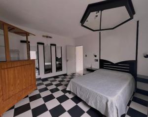 a bedroom with a bed and a checkered floor at Hotel De Campo Firmat in Firmat