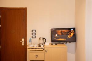a flat screen tv sitting on top of a dresser at Riwaq Pyramids View Inn & Rooftop in Cairo