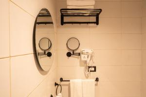 a bathroom with two mirrors and a sink with towels at Riwaq Pyramids View Inn & Rooftop in Cairo