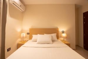 a bedroom with a white bed with two lamps at Riwaq Pyramids View Inn & Rooftop in Cairo +86 photos