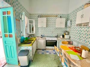 a kitchen with a sink and a table with chairs at Dar El Mdina in Mahdia +14 photos