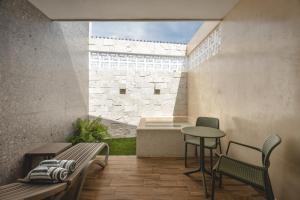 a patio with a table and chairs and a bench at Suite Deluxe con piscina privada en Valladolid - Penca Leonor 11 in Valladolid