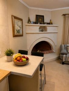 a bowl of fruit on a kitchen counter with a fireplace at Pipitsa's House-Votsalakia Beach in Votsalákia
