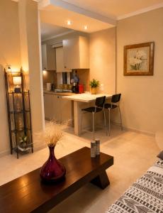 a living room and kitchen with a vase on a table at Pipitsa's House-Votsalakia Beach in Votsalákia