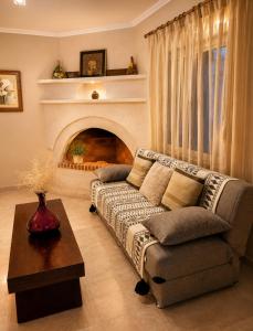 a living room with a couch and a fireplace at Pipitsa's House-Votsalakia Beach in Votsalákia