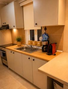 a kitchen with white cabinets and a sink at Pipitsa's House-Votsalakia Beach in Votsalákia