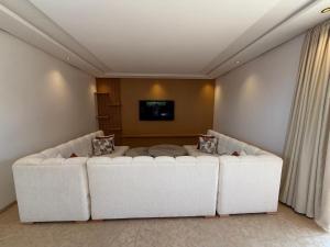 a living room with a white couch and a tv at Villa 74 Serenety in Heddad +32 photos