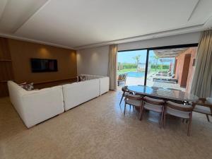 a living room with a table and a couch at Villa 74 Serenety in Heddad