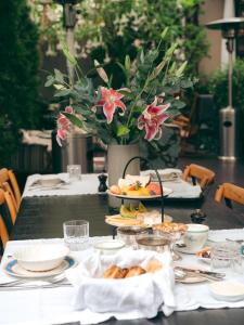 a table with plates of food and a vase with flowers at Atemporal by Andean in Lima