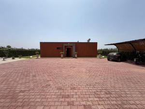 a brick parking lot with a building in the background at Villa 74 Serenety in Heddad
