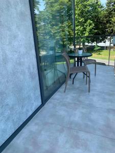a patio with two chairs and a table with glass windows at Na Rogu in Sandomierz