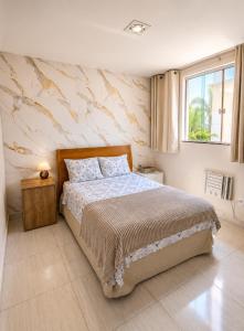 a bedroom with a large bed and a window at Pousada Recanto do Chef in Búzios
