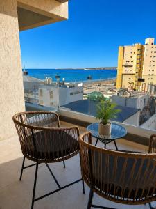 a patio with a table and chairs and a view of the ocean at House Vista Azul in Puerto Madryn