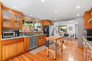 a kitchen with wooden cabinets and a wooden table at Redwood Oasis - Luxe Santa Cruz Cabin w/ Hot Tub in Ben Lomond
