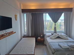 a hotel room with two beds and a window at Bariloche del Sur in San Carlos de Bariloche