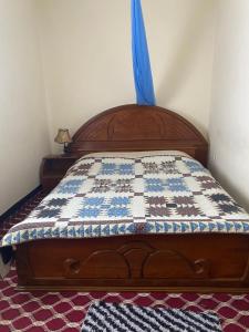 a bed with a quilt on it in a room at Cultural guest house in Hārer