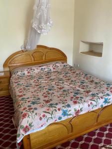 a bedroom with a bed with a floral bedspread at Cultural guest house in Hārer