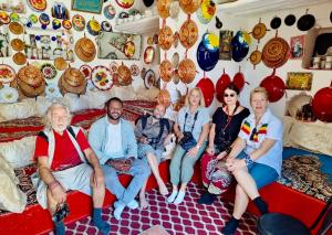 a group of people sitting on a couch in a room with vases at Cultural guest house in Hārer