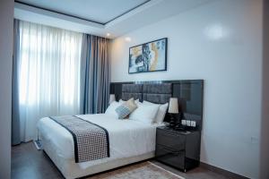 a hotel room with a bed and a window at Kiara Apartments in Kigali