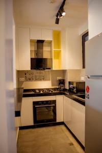a kitchen with white cabinets and a stove top oven at Kiara Apartments in Kigali