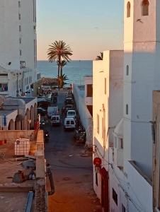 a view of a street with buildings and the ocean at Dar El Mdina in Mahdia