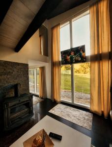 a living room with a fireplace and a large window at Kućica Sreće in Visoko