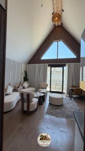 a large living room with couches and a large window at شاليهات البدرية لبيوت العطلات in Taif