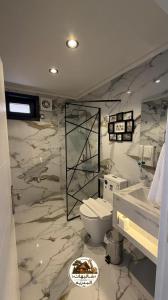 a marble bathroom with a toilet and a sink at شاليهات البدرية لبيوت العطلات in Taif +20 photos