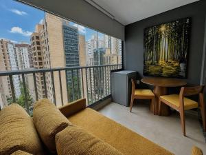 a living room with a couch and a large window at On Jurupis - Livinn by Travel Inn OJ1 in São Paulo