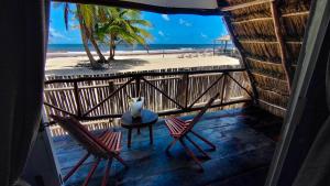 a balcony with two chairs and a table and the beach at Hotel Boutique Sylvie in Mahahual