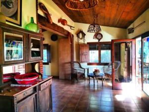 a kitchen with a table and a dining room at Can Micos - Masía de grupos 16 hasta 25 personas in Riudarenes