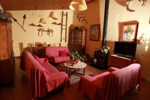 a living room with pink couches and a table at Can Micos - Masía de grupos 16 hasta 25 personas in Riudarenes