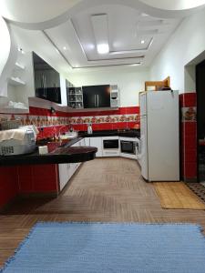 a kitchen with a white refrigerator and a blue rug at villa ourika complette in Sbiti