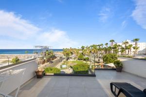 a balcony with a view of the beach and the ocean at WAKE UP BY THE SEA BEACHFRONT FLATS - Protaras in Protaras