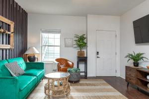 a living room with a green couch and a table at Couples Condo Retreat Overlooking Golf Course in Branson West