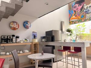 a kitchen with a counter and a table with chairs at Barranco Boutique Hotel by 3B in Lima