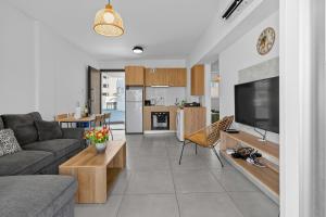 a living room with a couch and a tv at WAKE UP BY THE SEA BEACHFRONT FLATS - Protaras in Protaras