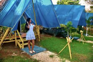 a woman in a dress standing next to a tent at Glamping Tesoro Escondido in San Antero