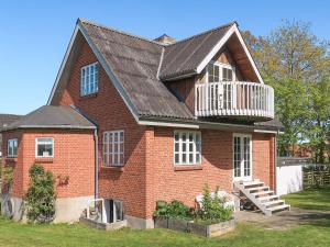 a red brick house with a balcony on it at Unique Coastal Retreat - By Traum Ferienwohnungen in Hadsund