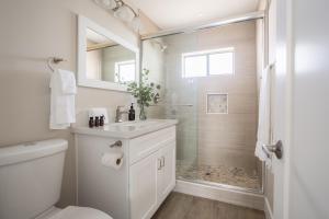 a white bathroom with a shower and a sink at Seashore Suites by AvantStay in San Diego +74 photos